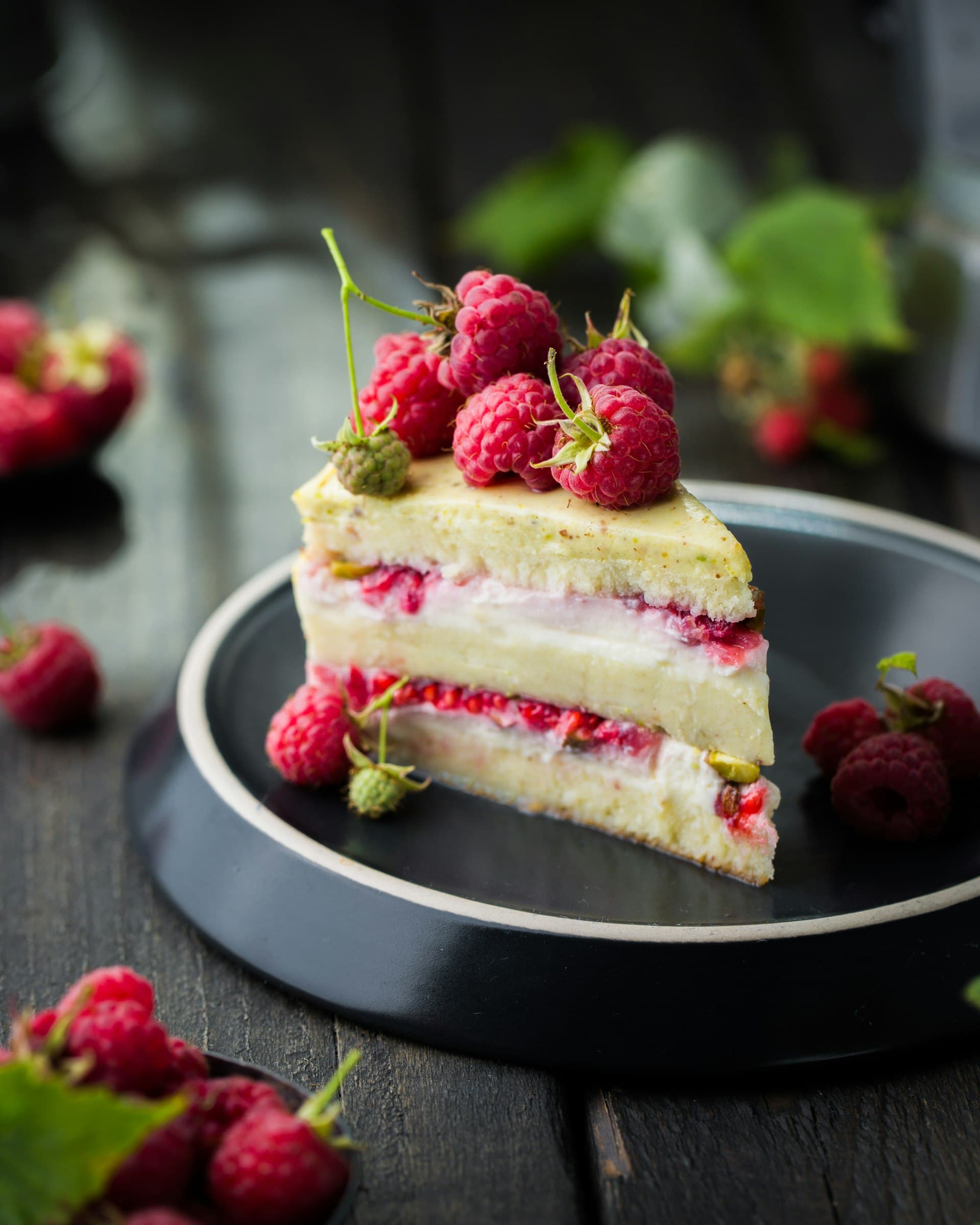 Slice of layered celebration cake with raspberries