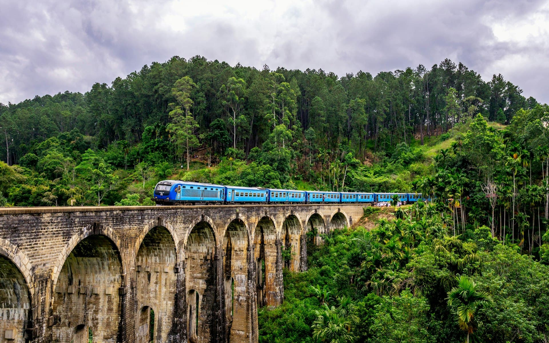 Arched railway bridge surrounded by green hills in Sri Lanka